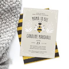 a card with a bee on it next to a pile of pom poms