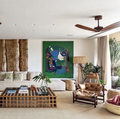 a living room filled with lots of furniture next to a painting on the wall above a coffee table