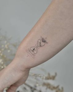 a woman's arm with a small tattoo on it