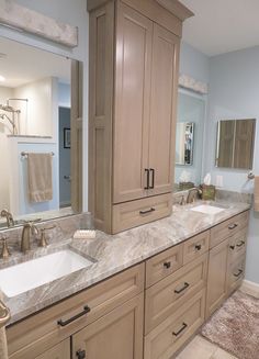 a large bathroom with two sinks and cabinets