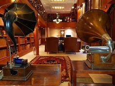 a large room with many bookshelves and antique items on the floor in front of them