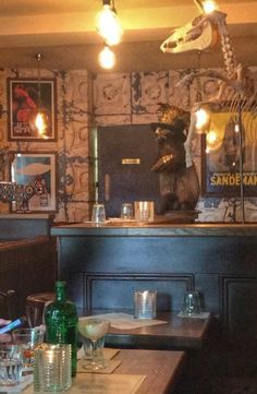 a restaurant with tables, chairs and stuffed animals on the wall behind it's bar