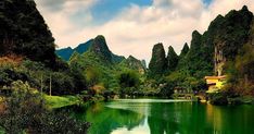 a lake surrounded by mountains in the middle of a green valley with trees on both sides