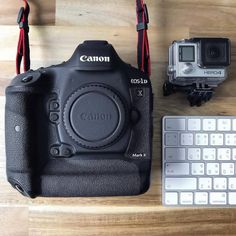 a camera and keyboard sitting on a table next to each other with the flash attached