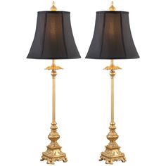 two lamps with black shades on each one and gold trim around the base, both in different sizes