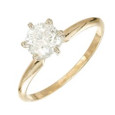 a yellow gold engagement ring with an oval diamond