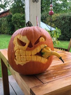 a pumpkin carved to look like a monster with teeth and fangs on it's face