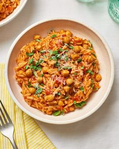 two bowls filled with pasta and garnished with parsley