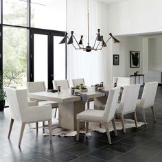 an image of a dining room setting with white chairs and a large table in the middle