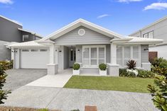 a house with white shutters and grass in front