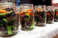 several mason jars filled with different types of veggies on a white table cloth