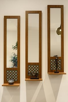 three wooden mirrors mounted to the side of a wall