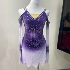 a purple and white figure skating dress on display