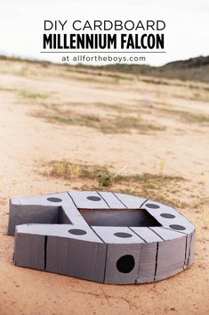 a cardboard box sitting in the middle of a dirt field with text overlay that reads diy cardboard millennium falcon