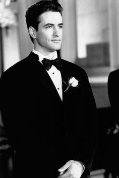 a black and white photo of a man in a tuxedo