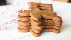 a stack of gingerbread cookies sitting on top of a table next to candy canes