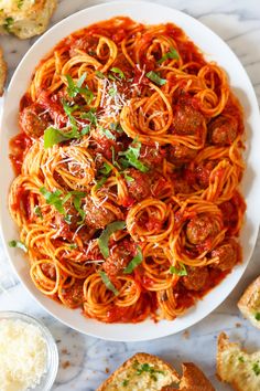 a plate of spaghetti with meatballs and parmesan bread