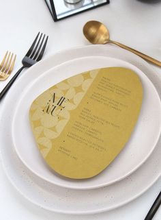 a white plate topped with a yellow and black place setting