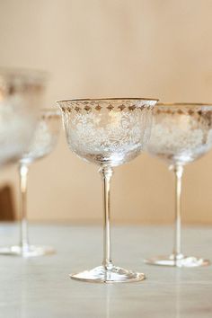 three wine glasses sitting on top of a table