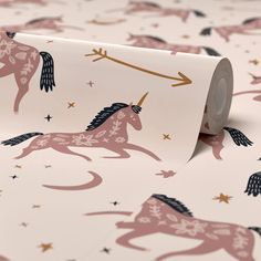 a roll of pink unicorn wallpaper with gold stars and an arrow on the top