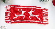 a red and white knitted placemat with reindeers on it