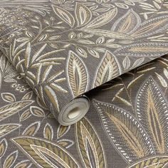 a close up view of a wallpaper with gold and grey leaves on it's surface