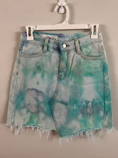 Blue and green tone ice dye on a thrifted white denim skirt w/ pockets on the front and back. The skirt is labeled a Women's size Small, 100% cotton, and should be machine washed in cold water with dark or like colors. *THIS IS AN UPCYCLED ITEM* upcycled; upcycling : to recycle (something) in such a way that the resulting product is of a higher value than the original item : to create an object of greater value from (a discarded object of lesser value) Green Cotton Denim Skirt For Spring, Cutoff Cotton Denim Skirt In Grunge Style, Faded Cotton Denim Skirt For Spring, Cotton Cutoff Denim Skirt In Grunge Style, Distressed Cotton Skirt For Summer, Grunge Cotton Skirt For Summer, Hand Dyed Cotton Bottoms For Spring, Summer Cotton Distressed Skirt, Spring Hand Dyed Cotton Bottoms