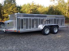 a trailer parked on gravel with trees in the background