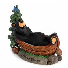 a figurine of a bear laying in a boat with a tree on it