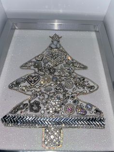 a christmas tree made out of many different types of buttons and jewels in a display case