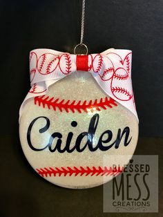 a baseball ornament hanging from a chain with the name candin on it