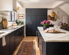 a kitchen with black cabinets and an area rug on the floor that matches the countertop