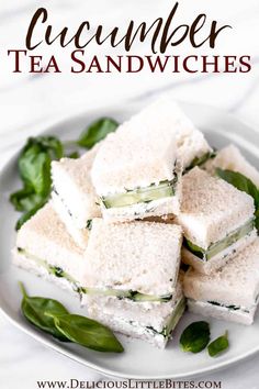 cucumber tea sandwiches stacked on top of each other with basil leaves around them