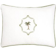 a white pillow with a palm tree on the front and green trimming around it