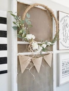 a wreath is hanging on the front door with burlocks and flowers in it