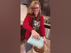 a woman is pouring something into a bucket