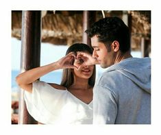 a man and woman standing next to each other with their hands on their foreheads