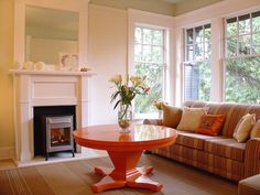 a living room filled with furniture and a fire place in front of a window next to a couch