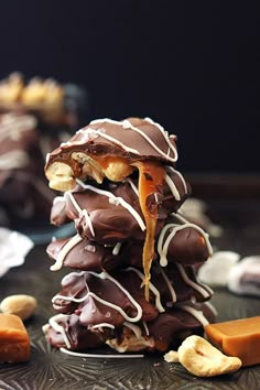 a stack of chocolate covered pretzels sitting on top of a table next to pieces of candy