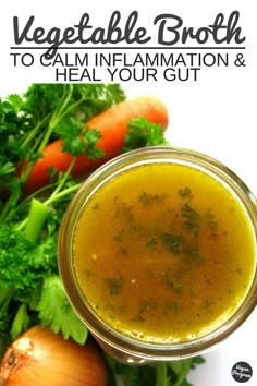 a jar filled with broth next to carrots and celery