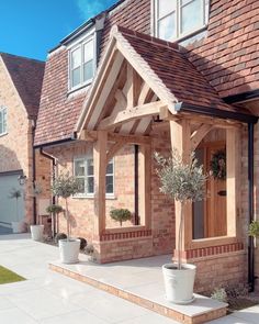 a brick house with potted plants on the front porch