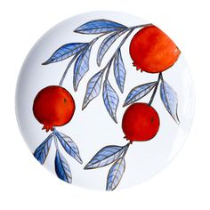 a plate with two pomegranates and leaves painted on it