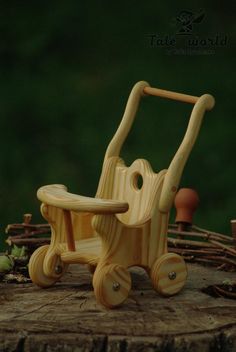 a wooden toy stroller sitting on top of a tree stump