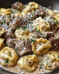 a plate full of pasta with meat and cheese on it, garnished with parsley