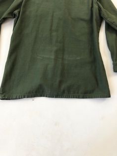 "USMC green cotton shirt circa 1971 has 'USMC' along with a globe screen printed on the chest pocket. The shirt has a button front, and cuffs, and chest pockets with buttoned flaps. Condition Overall excellent. Has some fade from wear near the back hem, a small stain near the button placket, and a tiny hole on the right arm near the shoulder. Measurements Chest 40\" Waist 38\" Shoulder 16.5\" Sleeve length 21.5\" Length 28\" Best for a size small." Green Military Crew Neck Top, Cotton Camp Shirt With Pockets And Long Sleeves, Long Sleeve Cotton Camp Shirt With Pockets, Cotton Long Sleeve Camp Shirt With Pockets, Retro Green Cotton Shirt, Green Retro Cotton Shirt, Cotton Long Sleeve Camp Shirt With Button Closure, Green Cotton Button-up Tops, Retro Long Sleeve Top With Pockets