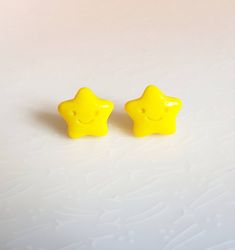 two yellow plastic stars sitting next to each other on a white surface with no one around them