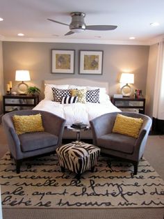 a bed room with a neatly made bed and two zebra print ottomans on the floor