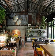 the inside of a restaurant with tables, chairs and shelves filled with bottles on them