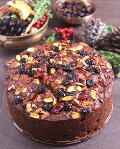 a chocolate cake with nuts and cherries on top, surrounded by other holiday decorations