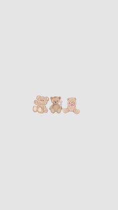 two small teddy bears sitting next to each other on a white surface with one bear facing the opposite direction